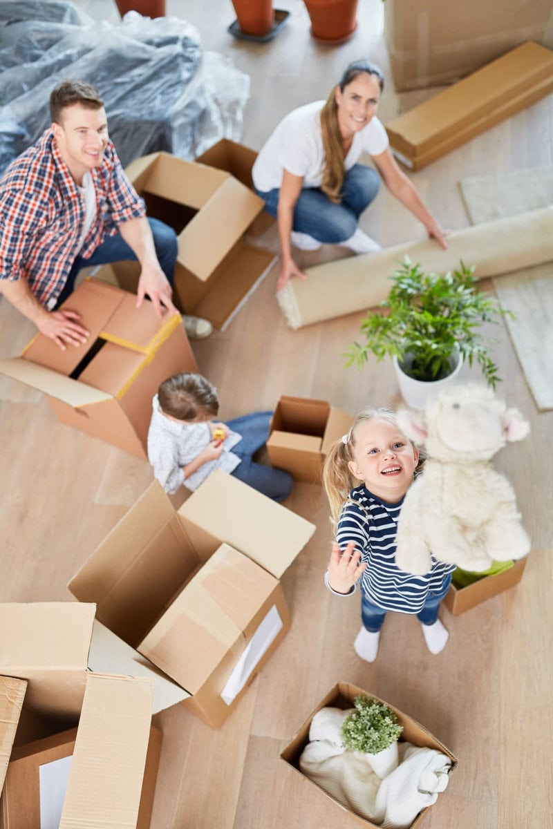 Familie packt Umzugskartons in einem hellen Raum